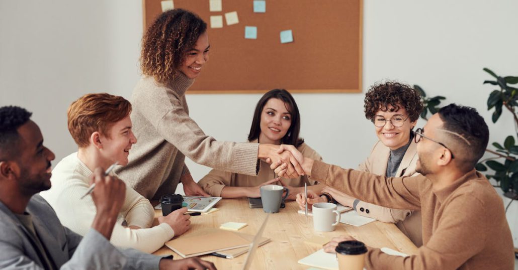 Diverse team collaborating in a meeting, showcasing teamwork and cooperation in a modern workplace.